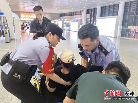 图为北京铁路公安局天津公安处民警救助旅客，将旅客抬至担架上。（北京铁路公安局天津公安处供图）