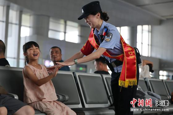 图为北京铁路公安局天津公安处民警帮助小朋友解决困难，和小朋友开心互动。(北京铁路公安局天津公安处供图)