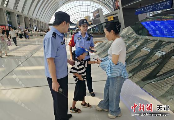 图为北京铁路公安局天津公安处天津西站派出所民警帮助走失男孩找到家人。(北京铁路公安局天津公安处供图）